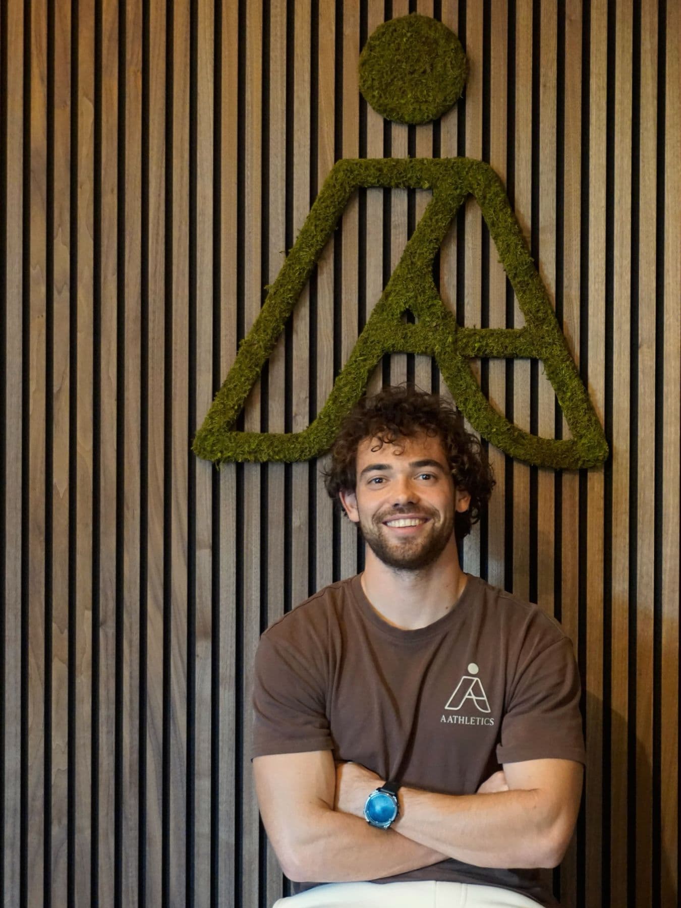 Aaron Dekkers voor het moslogo in de sportboetiek van Aathletics