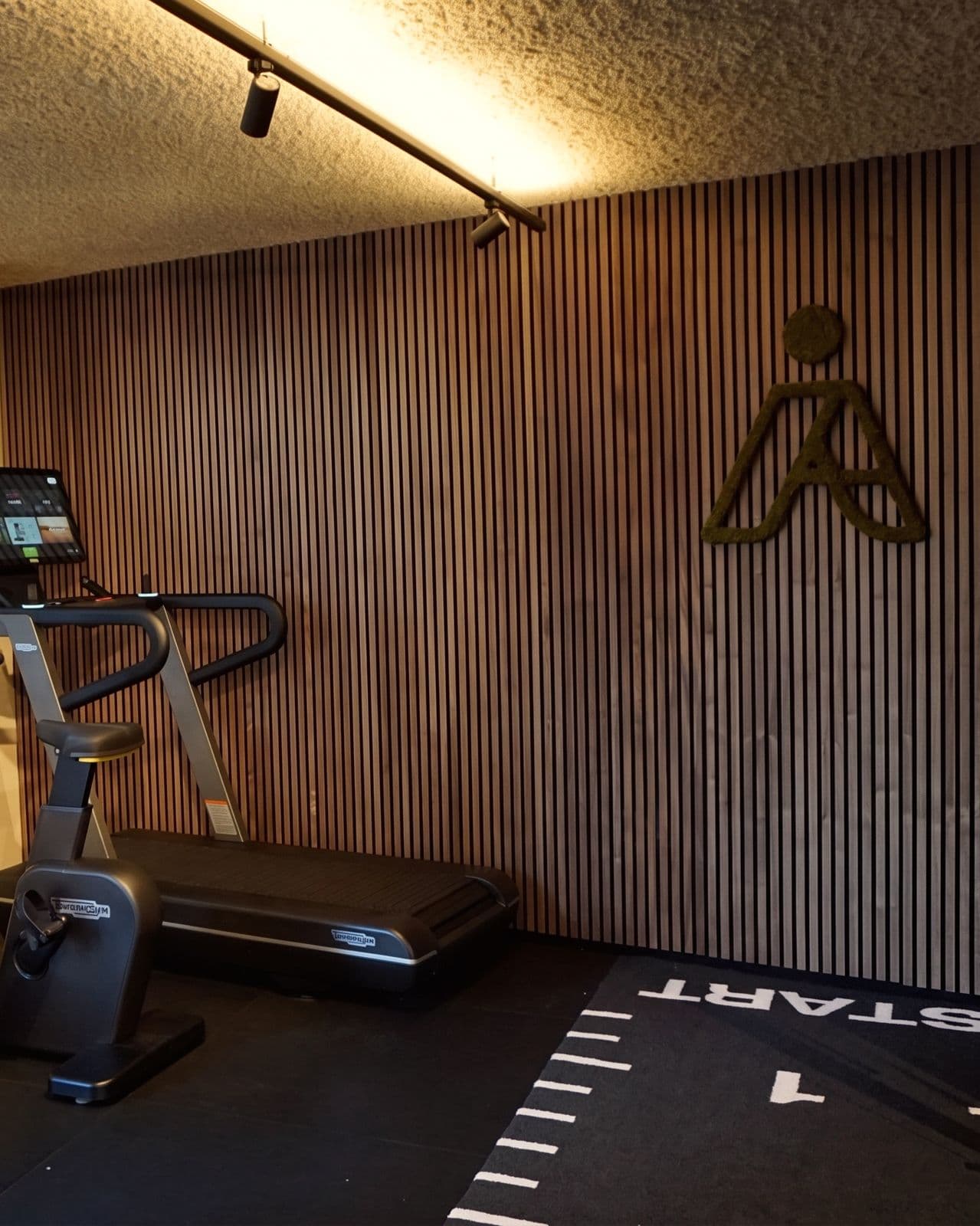 De trainingsruimte met de houten wand en het moslogo