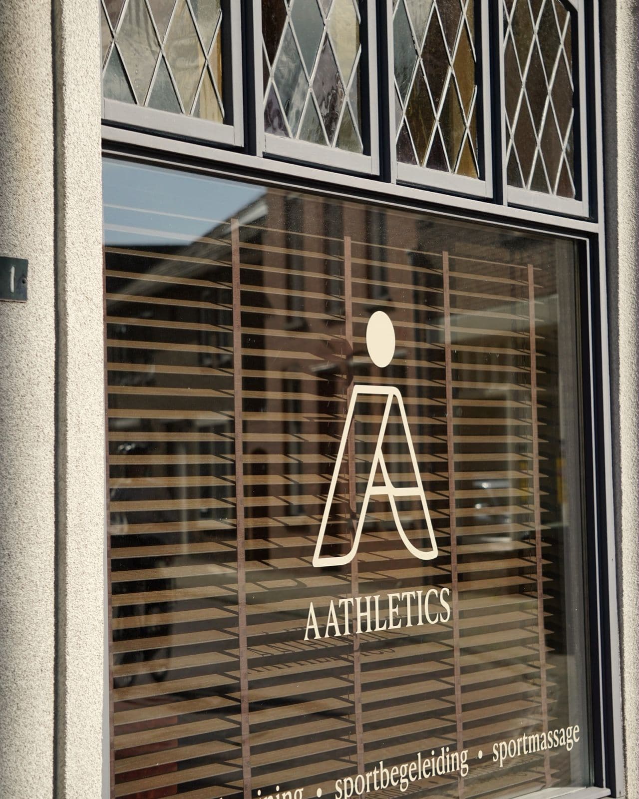 Het raam van Aathletics met het logo en de glas-in-loodramen